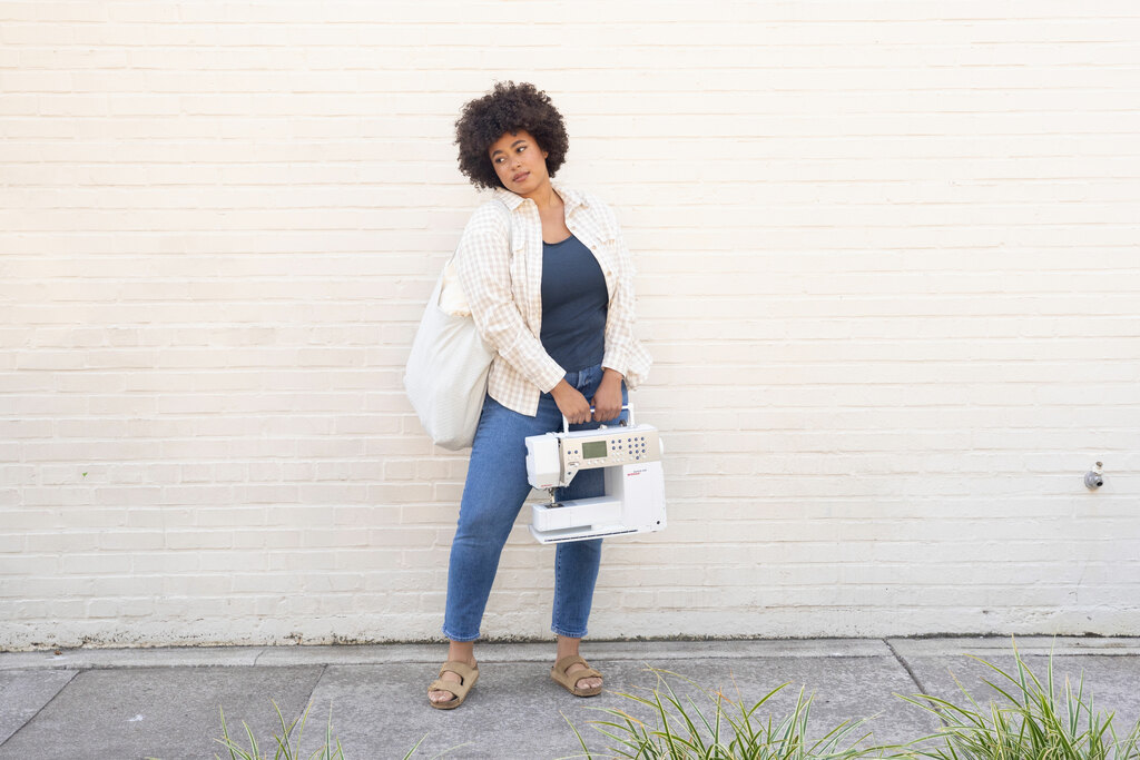 A woman holding a sewing machine