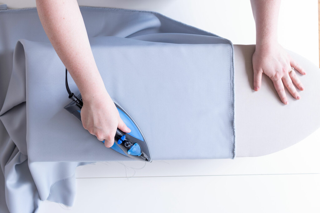 Someone pressing fabric with an iron