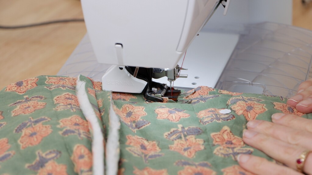Sewing machine with walking foot attached, sewing through quilted fabric